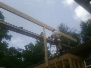 Carpenter setting a ridge beam over a new addition frame — Ice Dam Removal by Roofing Brothers in Menomonie