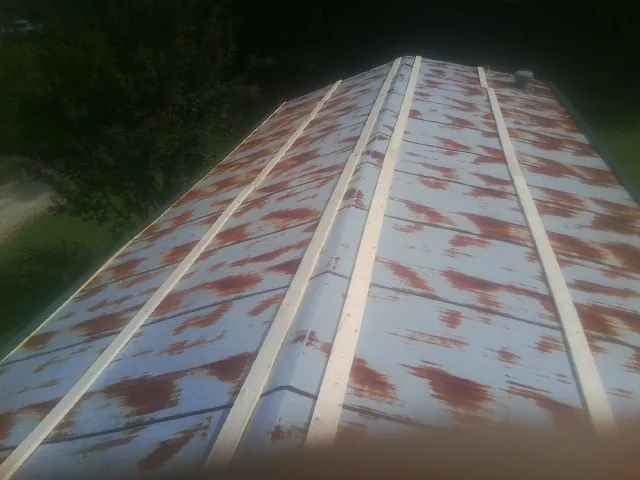 Rusted metal roof panels with new wood purlins before replacement — Storm Damage Roof Repair in Menomonie by Roofing Brothers