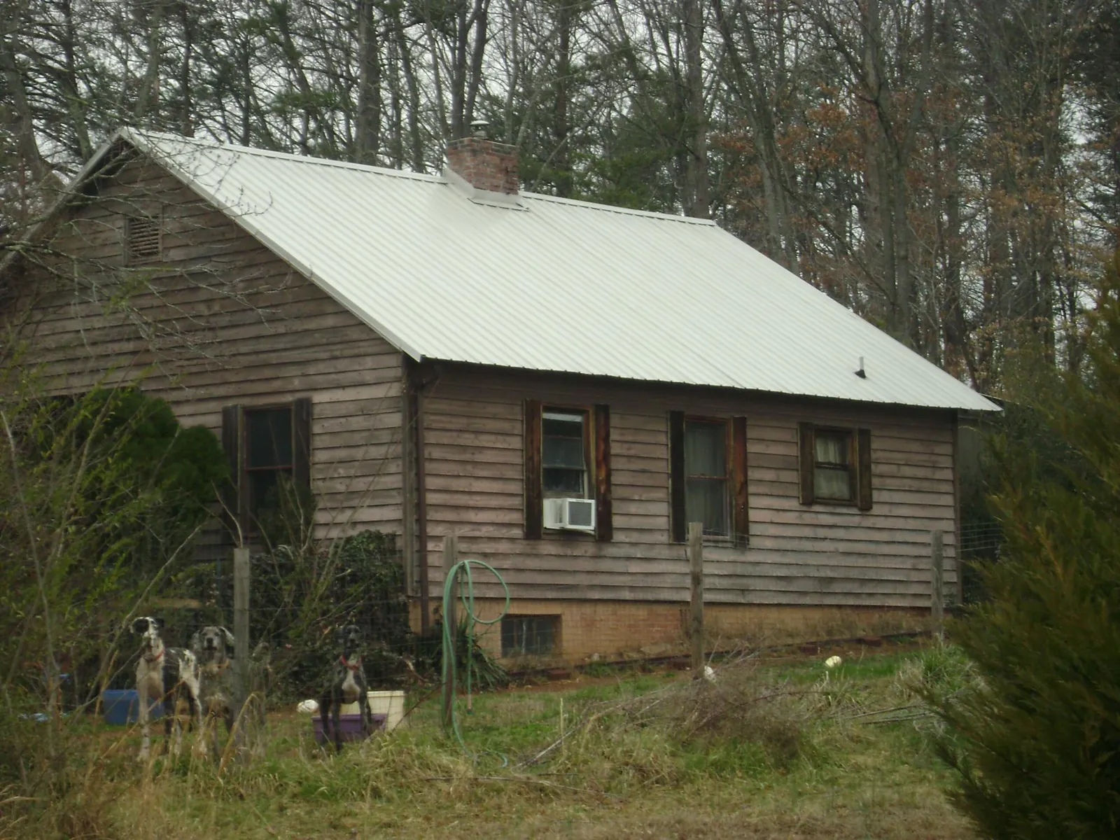 White metal roof on an old wood sided farmhouse, from a Metal Roof Installation job in Menomonie
